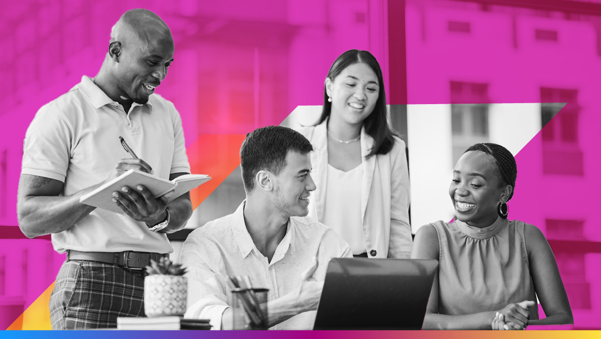 four people around a computer smiling