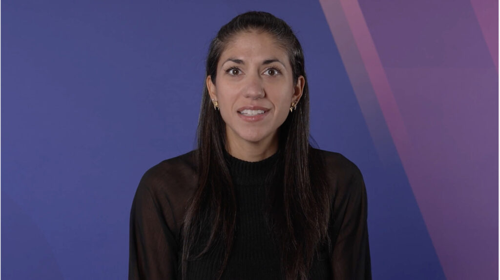 Person smiling in front of blue and purple background